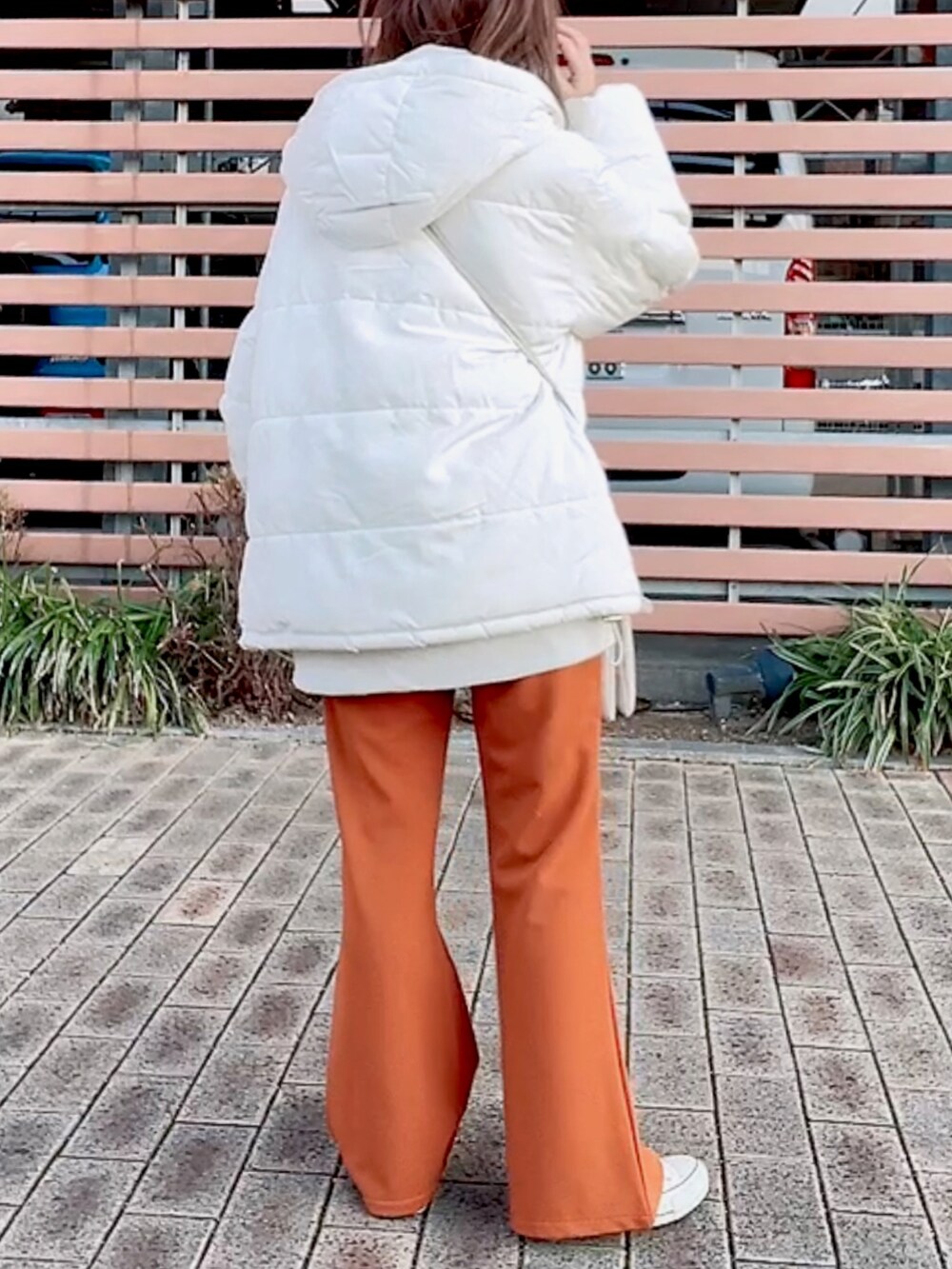 ホワイト系のダウンジャケット/コート、ベージュ系のスウェット、ホワイト系のショルダーバッグを着用したレディースの冬コーディネートの5枚目の写真