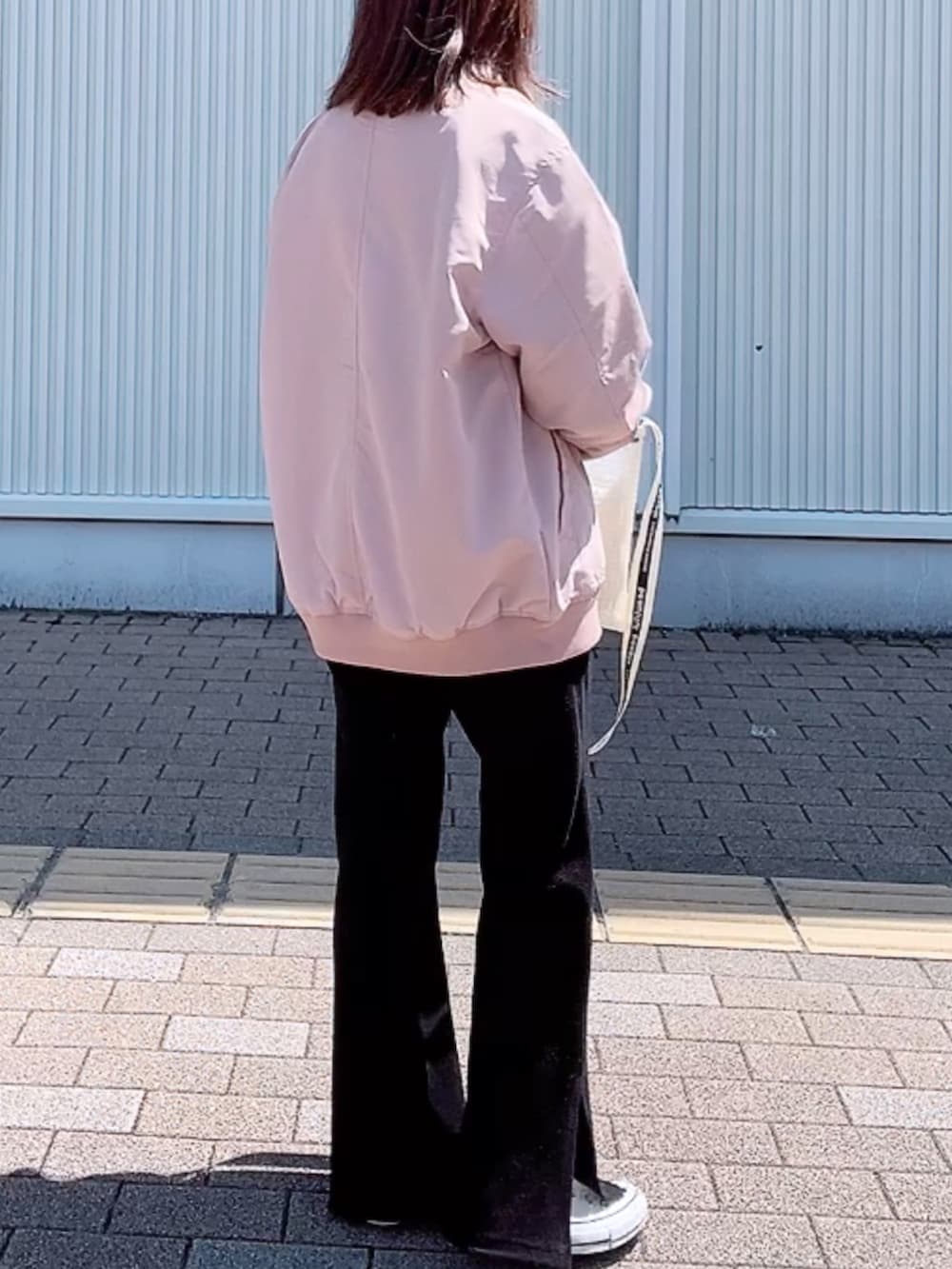 ピンク系のMA-1、ホワイト系のTシャツ/カットソー、ホワイト系のショルダーバッグを着用したレディースの春コーディネートの3枚目の写真