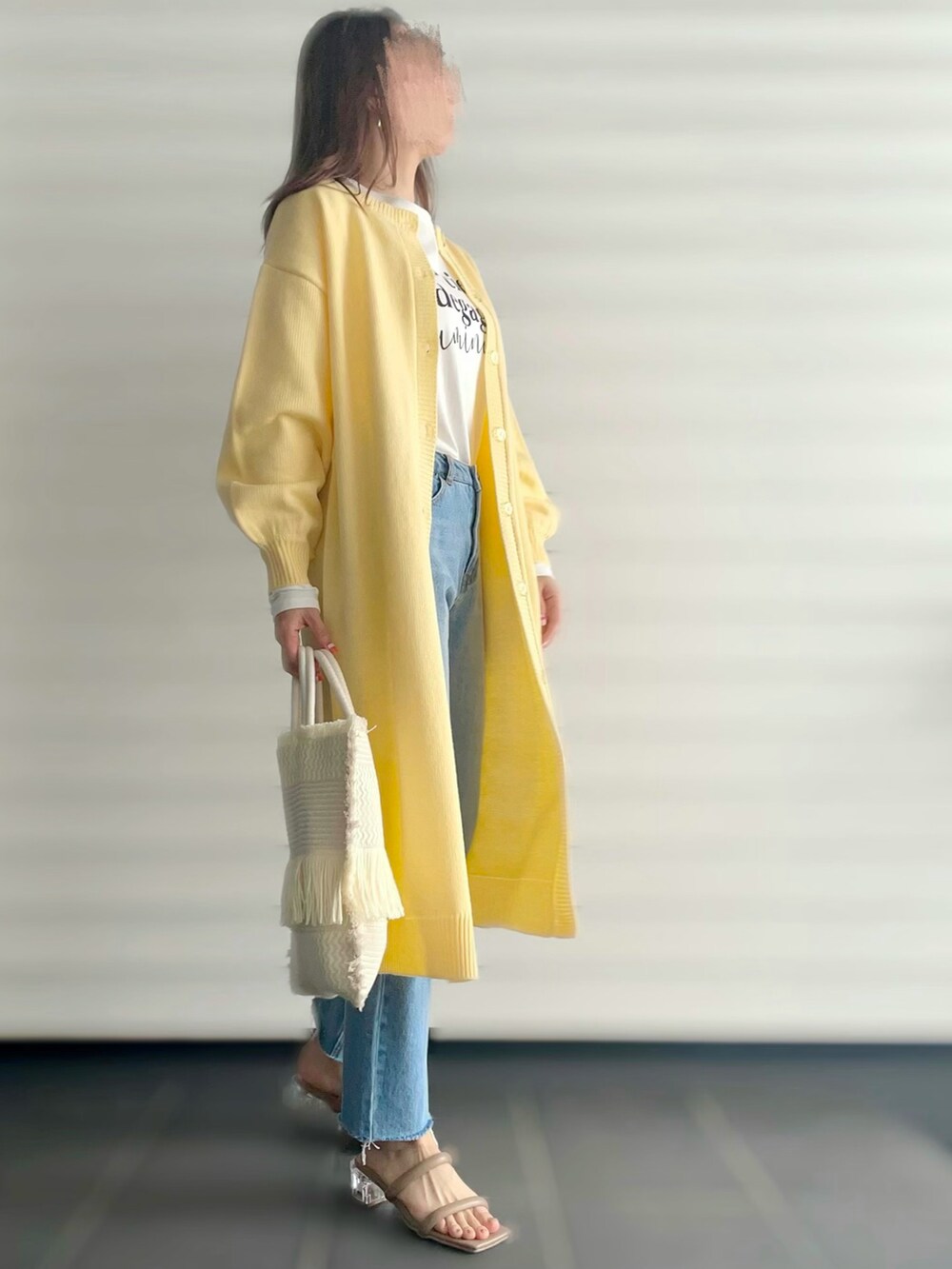 イエロー系のカーディガン/ボレロ、ホワイト系のTシャツ/カットソー、ブルー系のデニムパンツを着用したレディースの夏コーディネートの2枚目の写真