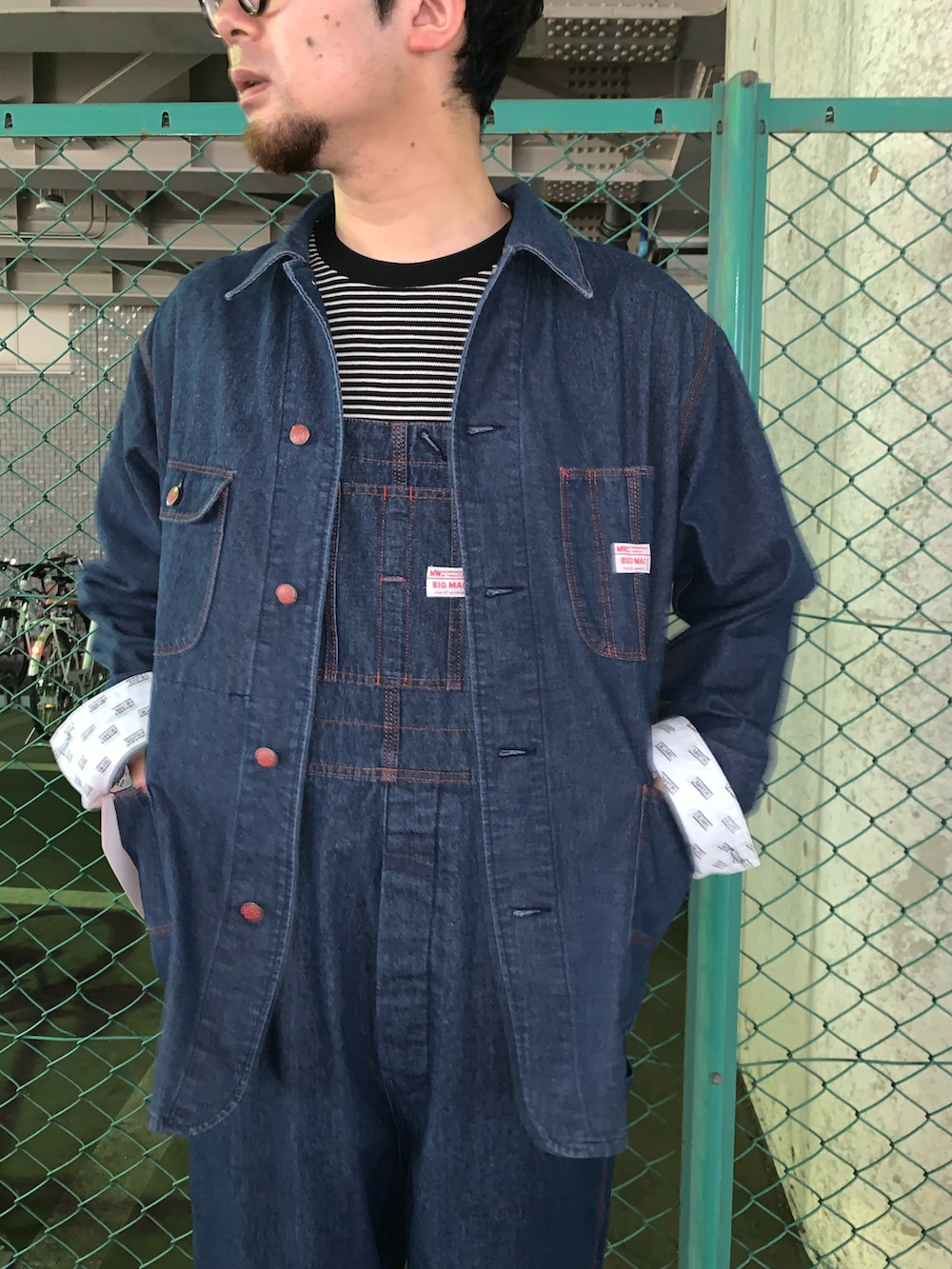 ブルー系のブルゾン、ブルー系のサロペット/オーバーオール、ブラック系のブーツを着用したメンズの秋コーディネートの2枚目の写真