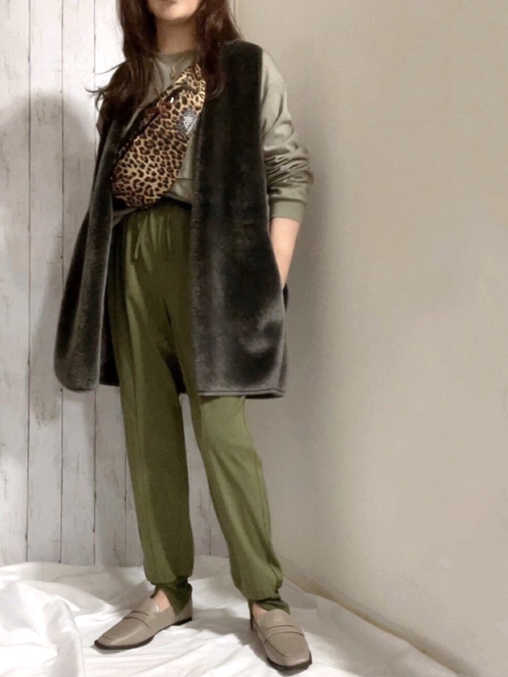 ブラウン系のマウンテンパーカー、グリーン系のトップス、グリーン系のパンツを着用したレディースの冬コーディネートの2枚目の写真