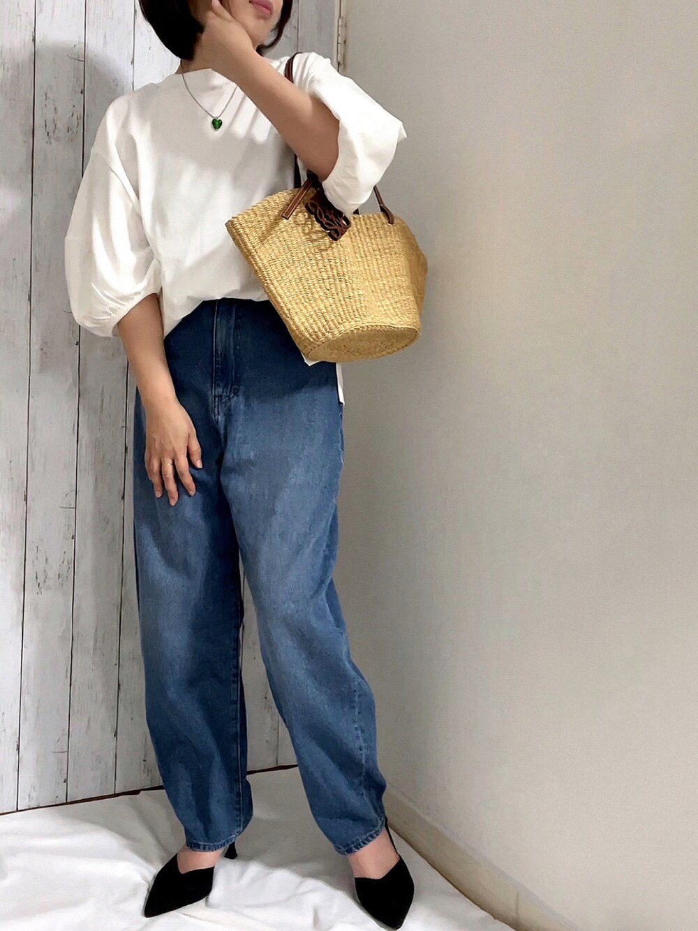 ホワイト系のTシャツ/カットソー、ブルー系のデニムパンツ、ベージュ系のかごバッグを着用したレディースの春コーディネートの2枚目の写真