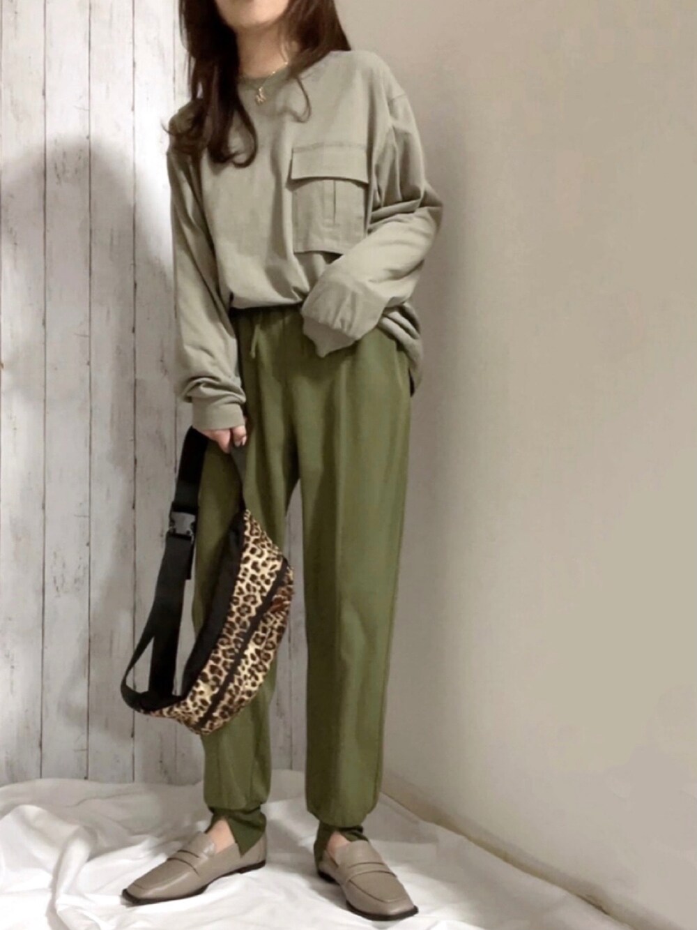 ブラウン系のマウンテンパーカー、グリーン系のトップス、グリーン系のパンツを着用したレディースの冬コーディネートの3枚目の写真