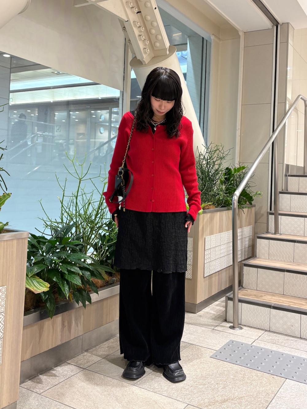 レッド系のカーディガン/ボレロ、ブラック系のショルダーバッグ、ブラック系のその他パンツを着用したレディースの冬コーディネートの4枚目の写真