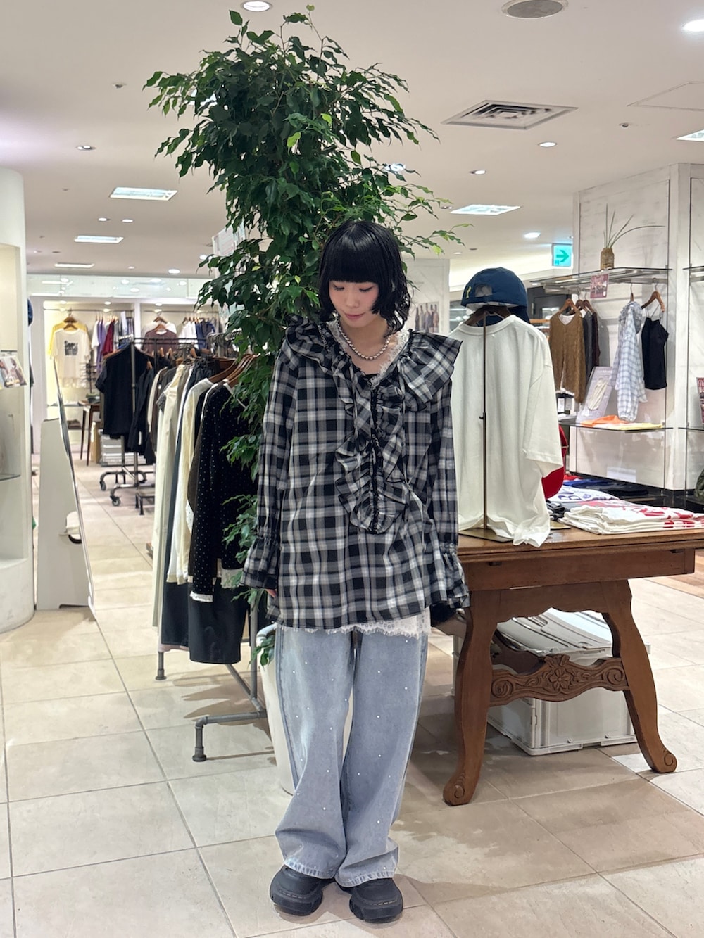 ブラック系のシャツ/ブラウス、ホワイト系のチュニック、ブルー系のデニムパンツを着用したレディースの秋コーディネートの5枚目の写真