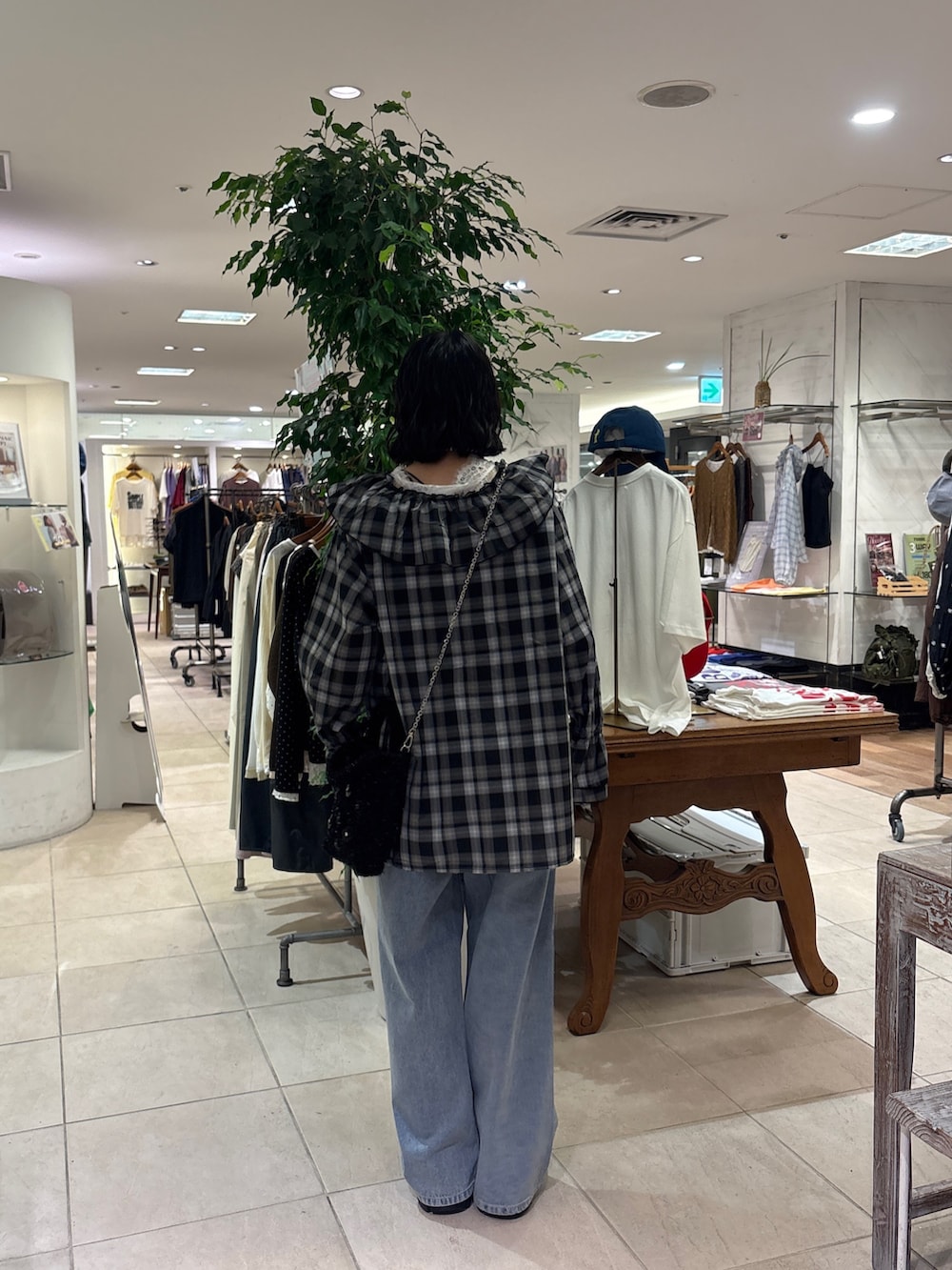 ブラック系のシャツ/ブラウス、ホワイト系のチュニック、ブルー系のデニムパンツを着用したレディースの秋コーディネートの4枚目の写真
