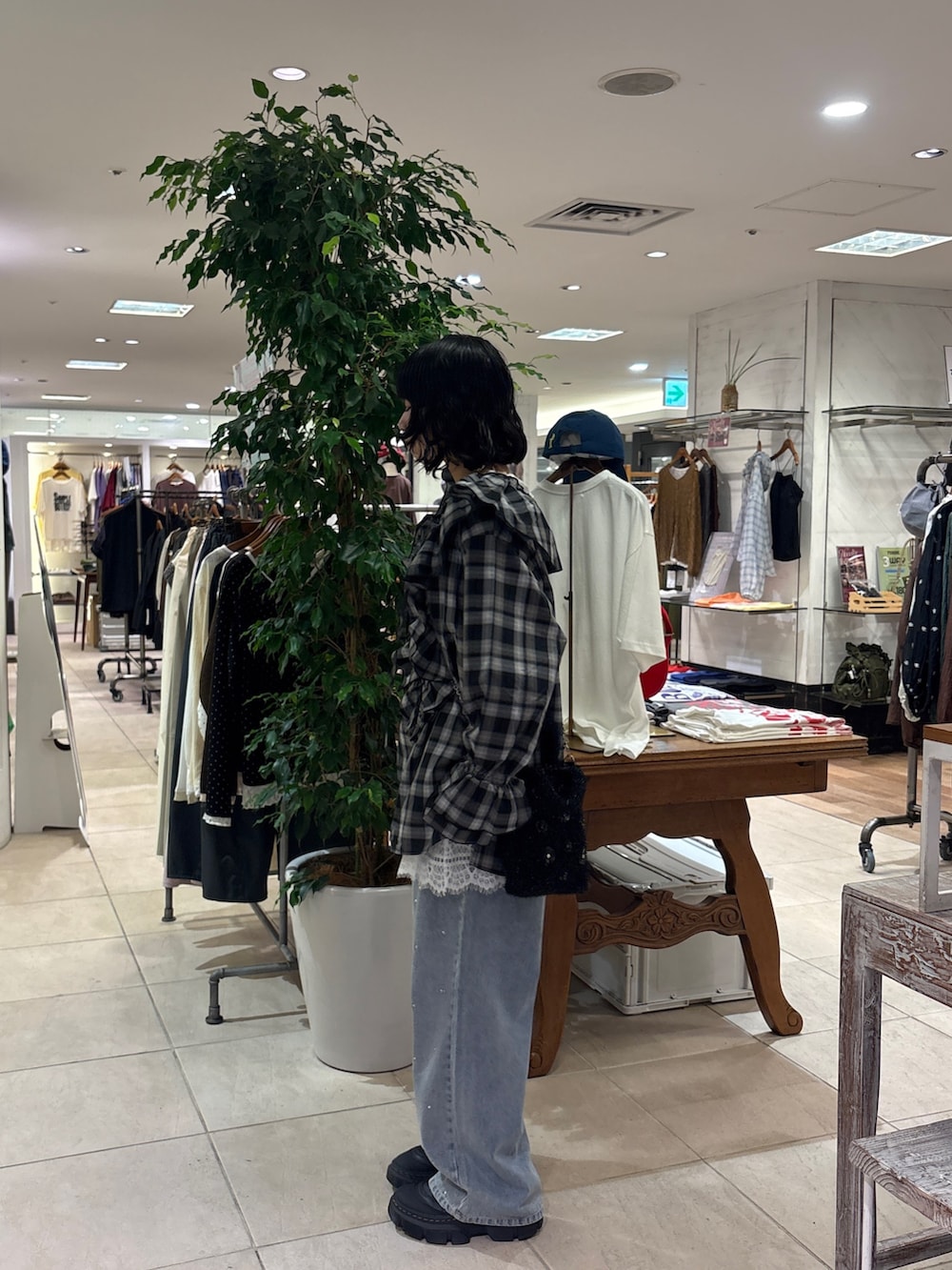 ブラック系のシャツ/ブラウス、ホワイト系のチュニック、ブルー系のデニムパンツを着用したレディースの秋コーディネートの3枚目の写真