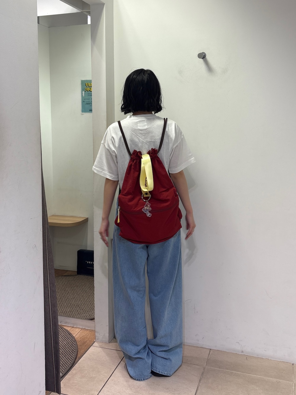 ホワイト系のTシャツ/カットソー、レッド系のバックパック/リュック、ブルー系のデニムパンツを着用したレディースの夏コーディネートの3枚目の写真