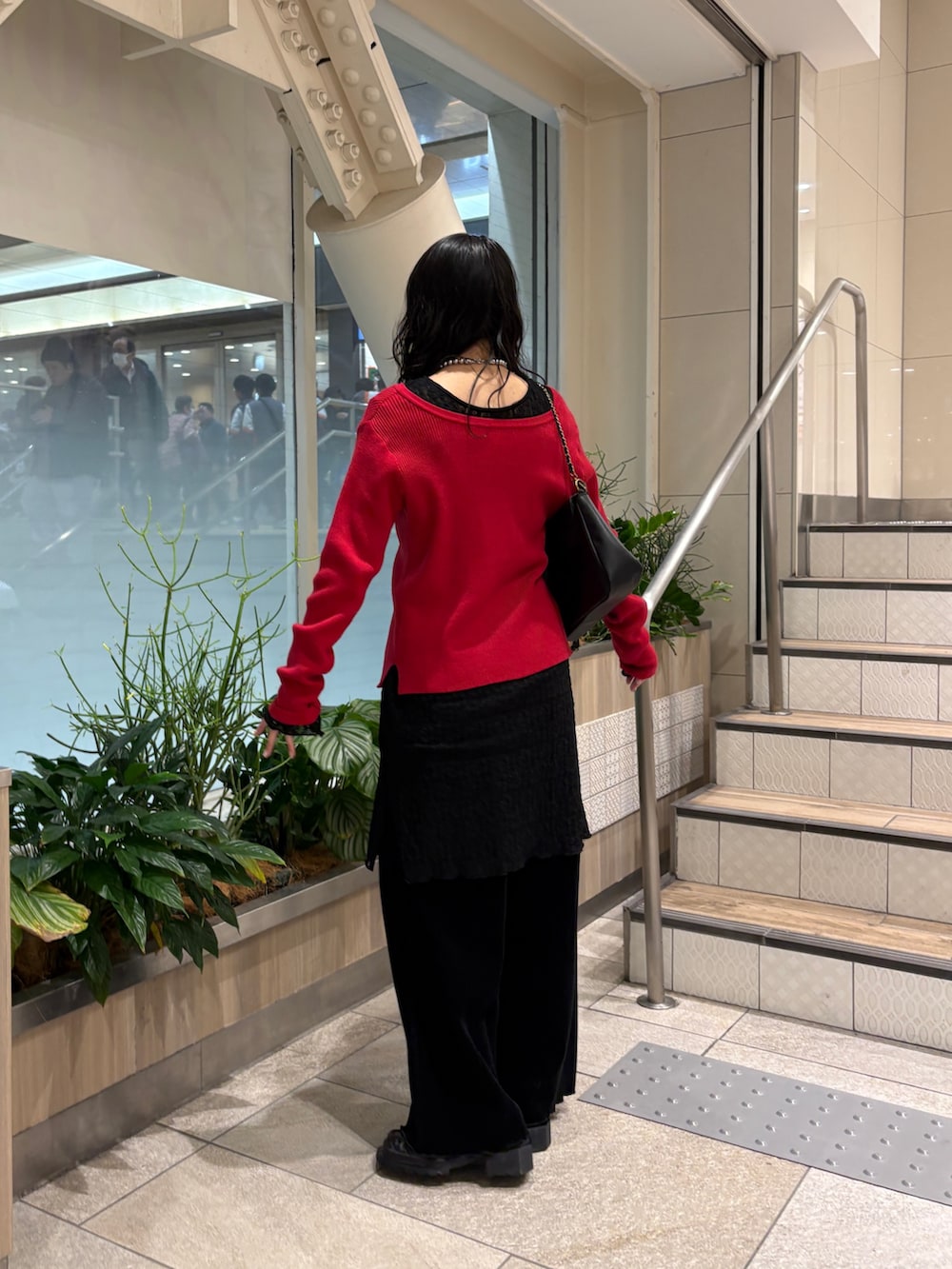 レッド系のカーディガン/ボレロ、ブラック系のショルダーバッグ、ブラック系のその他パンツを着用したレディースの冬コーディネートの3枚目の写真