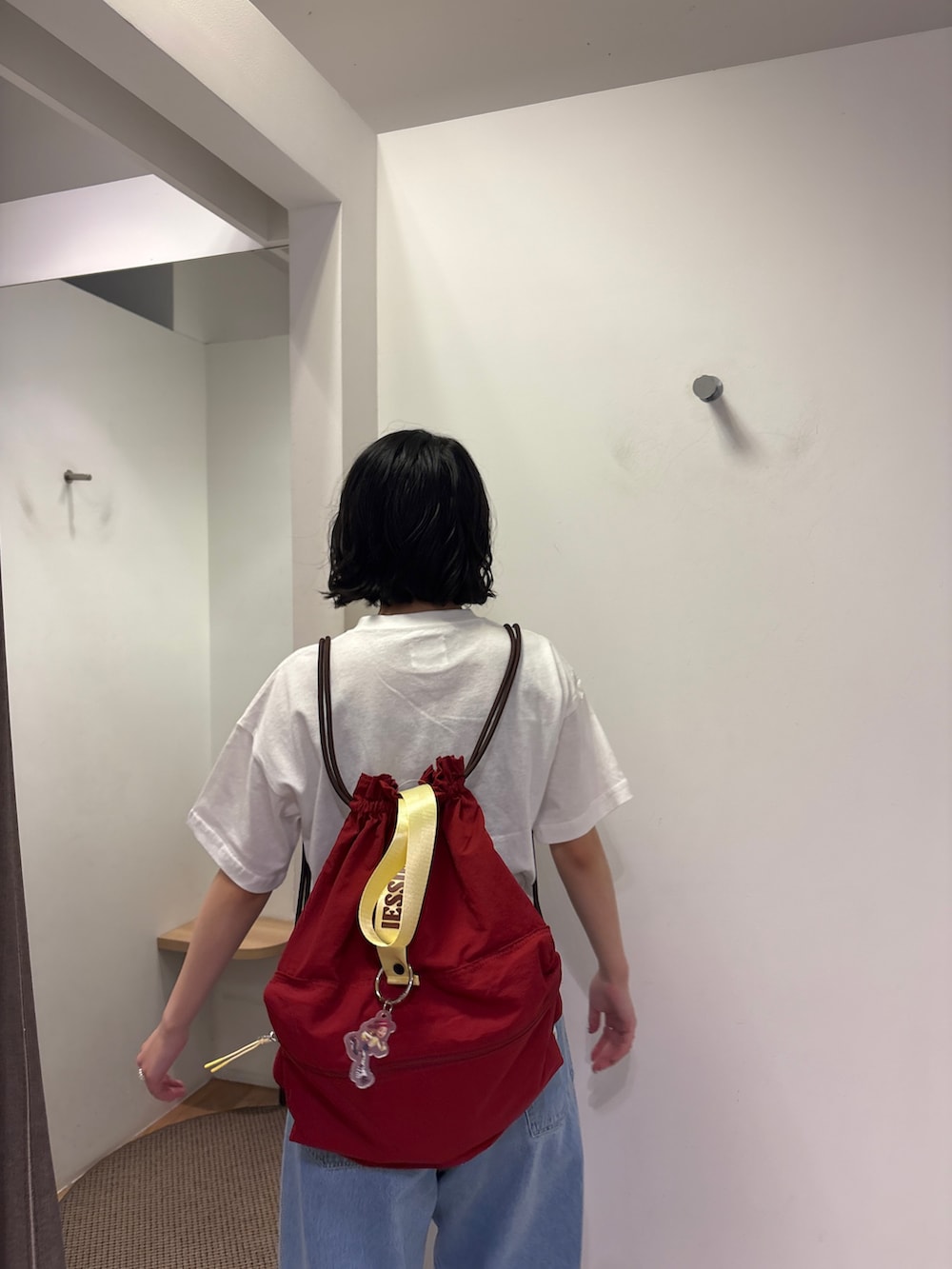 ホワイト系のTシャツ/カットソー、レッド系のバックパック/リュック、ブルー系のデニムパンツを着用したレディースの夏コーディネートの5枚目の写真