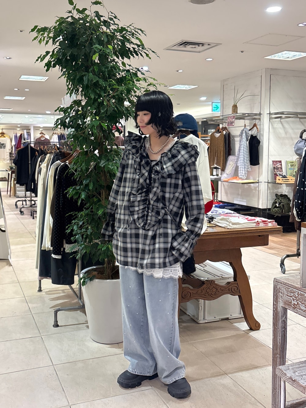 ブラック系のシャツ/ブラウス、ホワイト系のチュニック、ブルー系のデニムパンツを着用したレディースの秋コーディネートの2枚目の写真