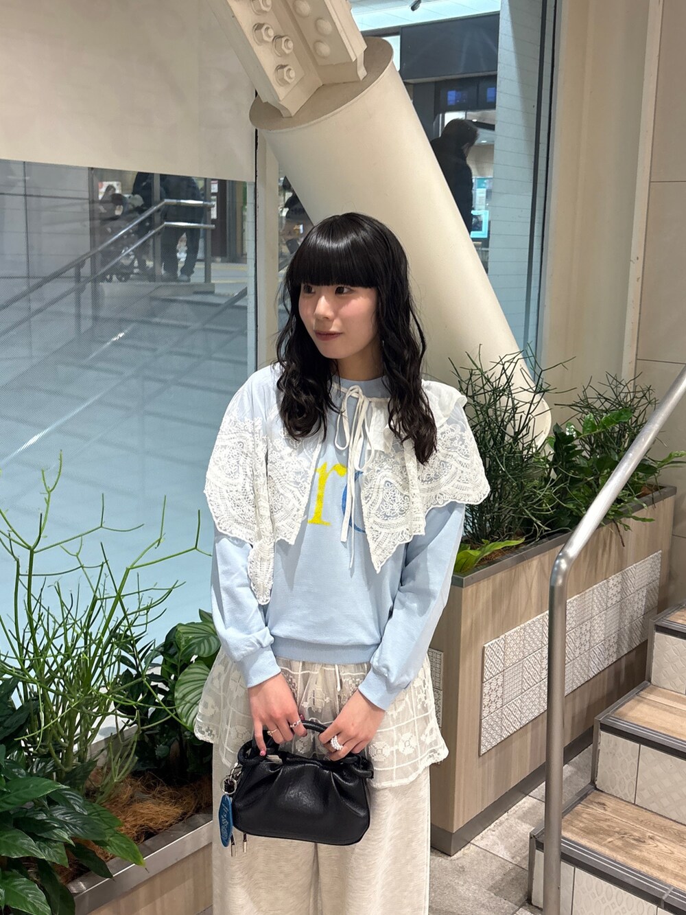 ブルー系のTシャツ/カットソー、ホワイト系のスカート、ブラック系のショルダーバッグを着用したレディースの冬コーディネートの4枚目の写真