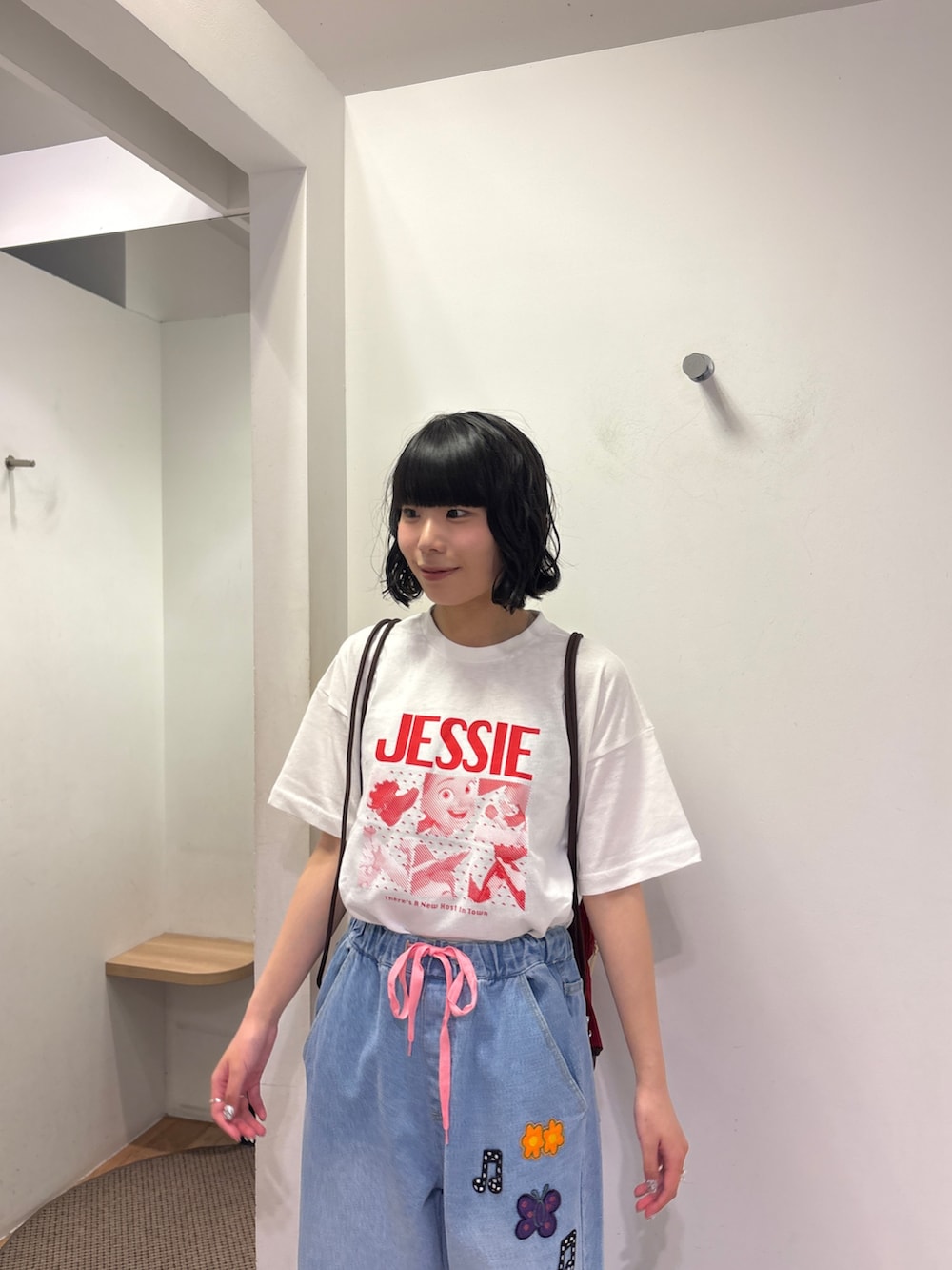 ホワイト系のTシャツ/カットソー、レッド系のバックパック/リュック、ブルー系のデニムパンツを着用したレディースの夏コーディネートの4枚目の写真