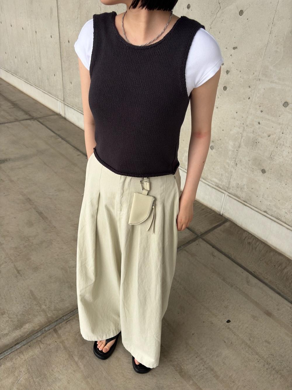 グレー系のベスト、ホワイト系のその他パンツ、ブラック系のサンダルを着用したレディースの夏コーディネートの4枚目の写真