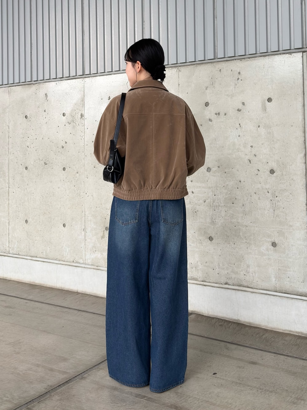 ブラック系のキャミソール、ブルー系のデニムパンツ、ベージュ系のブルゾンを着用したレディースの秋コーディネートの2枚目の写真