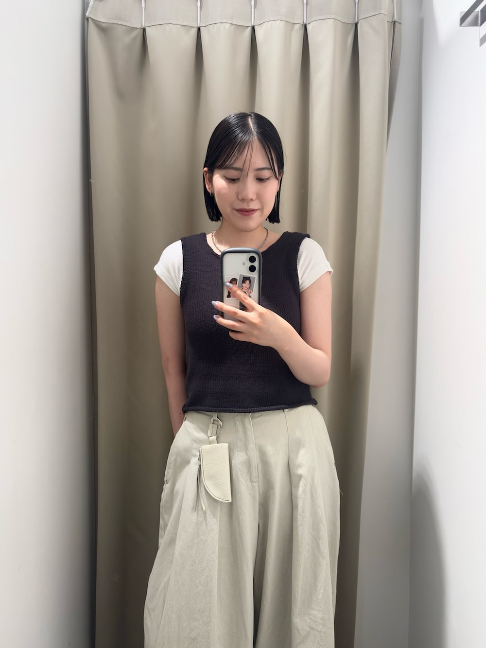グレー系のベスト、ホワイト系のその他パンツ、ブラック系のサンダルを着用したレディースの夏コーディネートの5枚目の写真