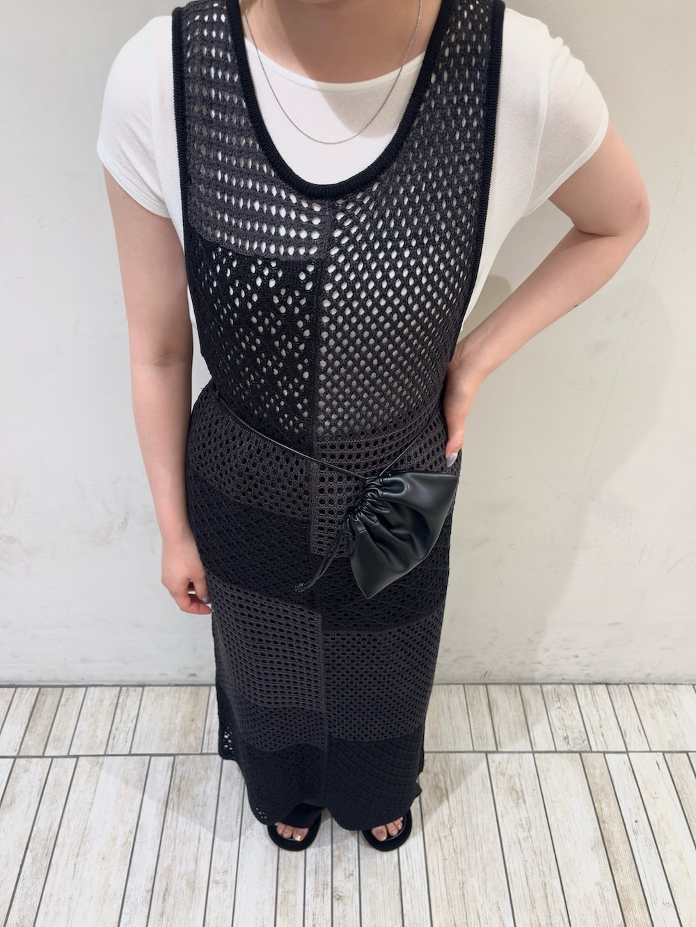 グレー系のワンピース、ホワイト系のTシャツ/カットソー、ブラック系のサンダルを着用したレディースの夏コーディネートの4枚目の写真