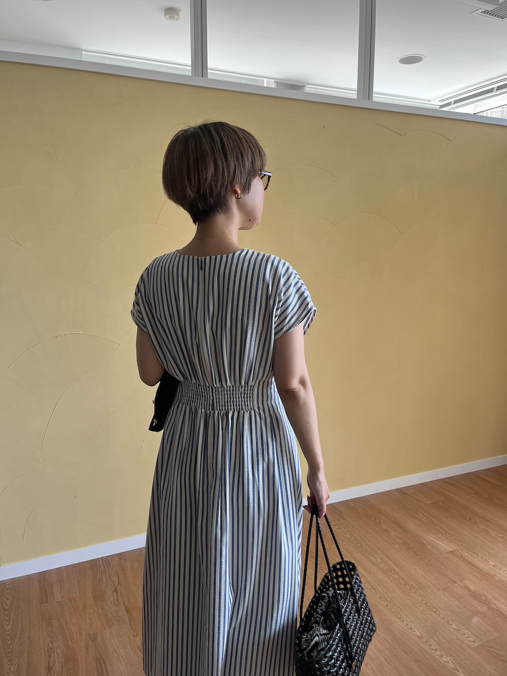ブラック系のカーディガン/ボレロ、ブラック系のトートバッグ、ブルー系のワンピースを着用したレディースの春コーディネートの6枚目の写真