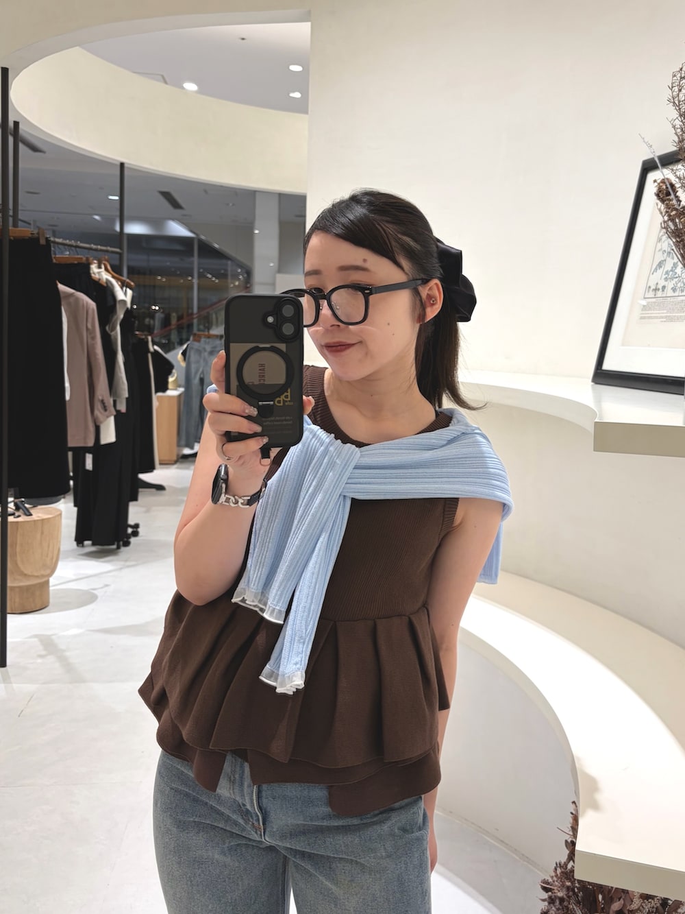 ブラウン系のニット/セーター、ブルー系のデニムパンツ、ブラック系のパンプスを着用したレディースの夏コーディネートの4枚目の写真