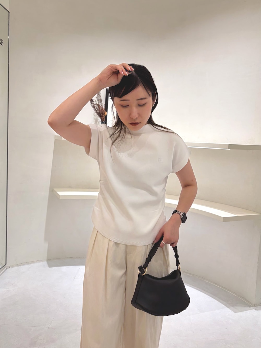 ブラック系のパンプス、ブラック系のショルダーバッグ、ホワイト系のその他パンツを着用したレディースの夏コーディネートの4枚目の写真