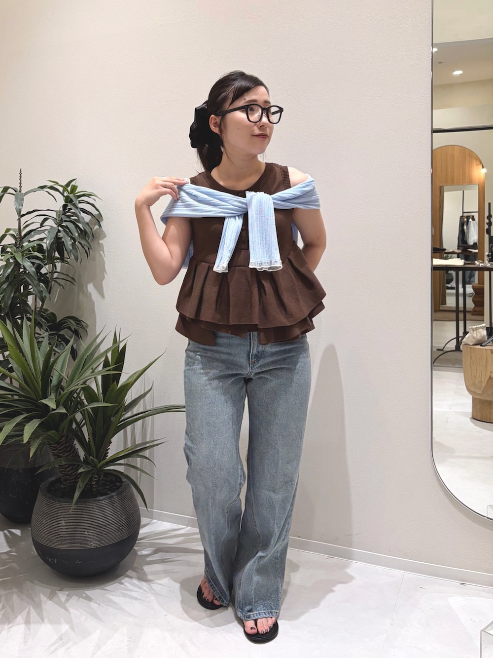 ブラウン系のニット/セーター、ブルー系のデニムパンツ、ブラック系のパンプスを着用したレディースの夏コーディネートの2枚目の写真
