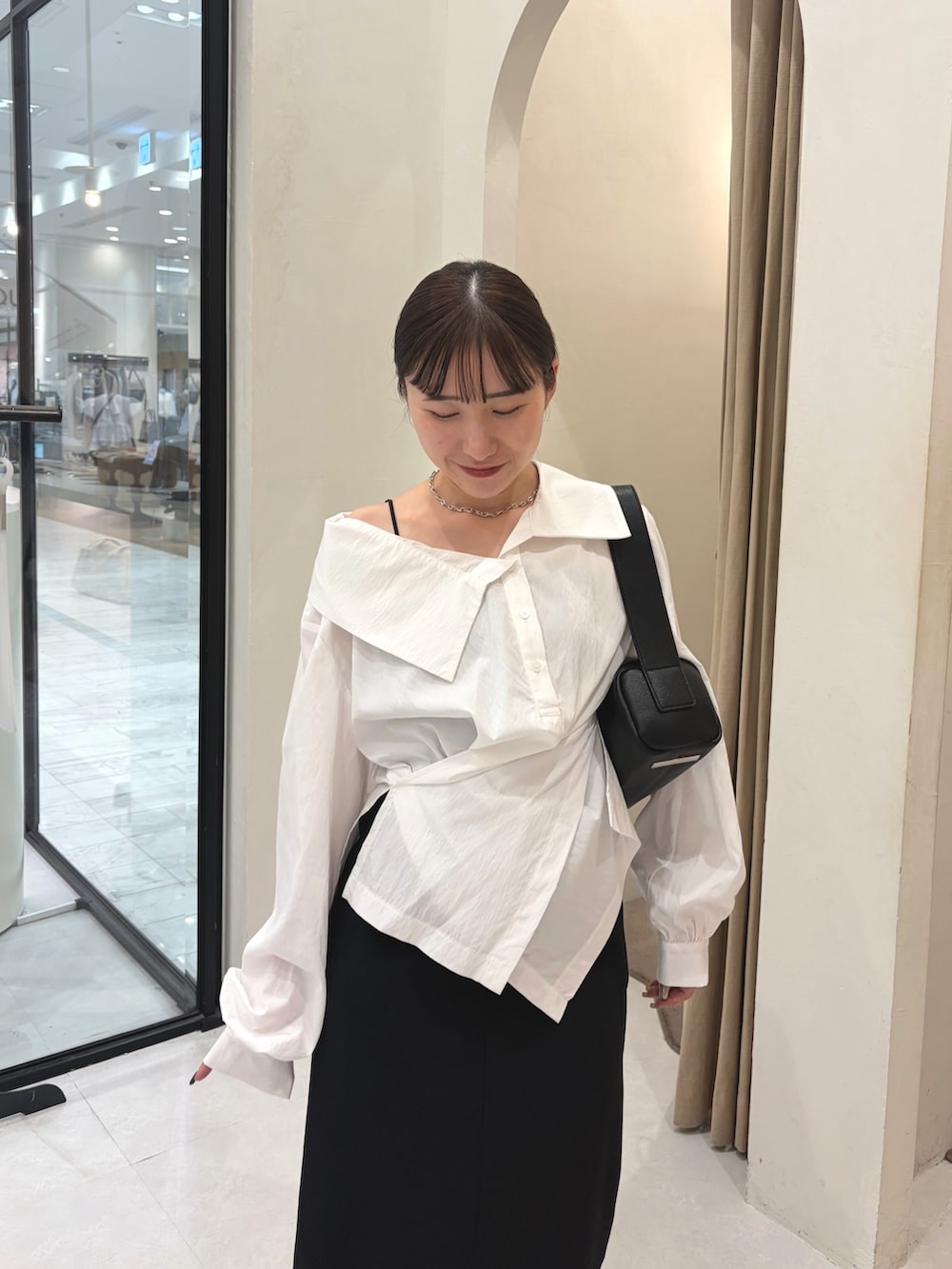 ホワイト系のシャツ/ブラウス、ブラック系のスカート、ブラック系のパンプスを着用したレディースの秋コーディネートの4枚目の写真