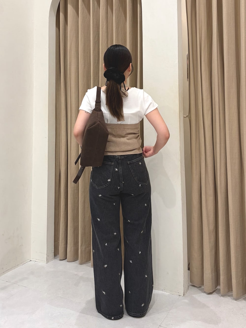ブラック系のデニムパンツ、ブラウン系のトートバッグ、ブラック系のローファーを着用したレディースの夏コーディネートの5枚目の写真