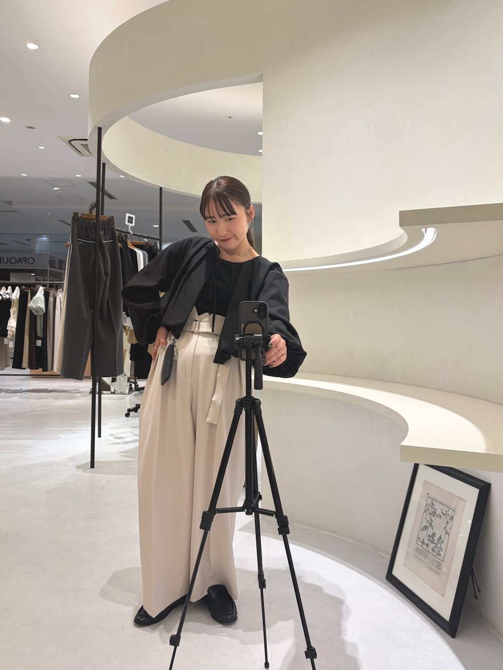 ホワイト系のその他パンツ、ブラック系のシャツ/ブラウス、ブラック系のショルダーバッグを着用したレディースの秋コーディネートの3枚目の写真