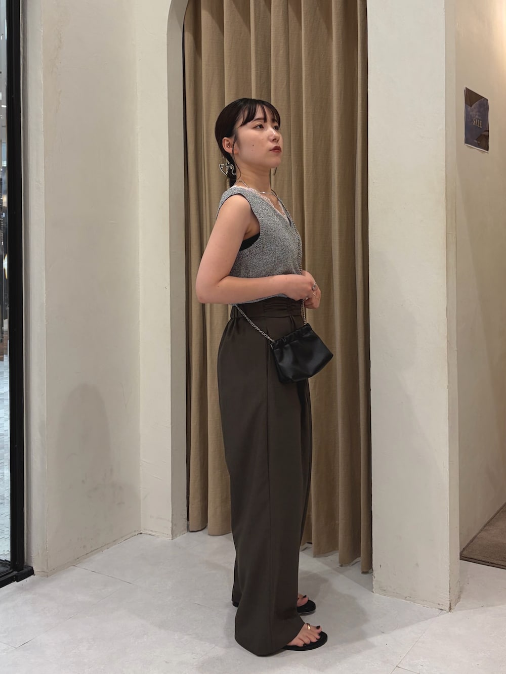 グレー系のニット/セーター、ブラウン系のその他パンツ、ブラック系のパンプスを着用したレディースの夏コーディネートの3枚目の写真