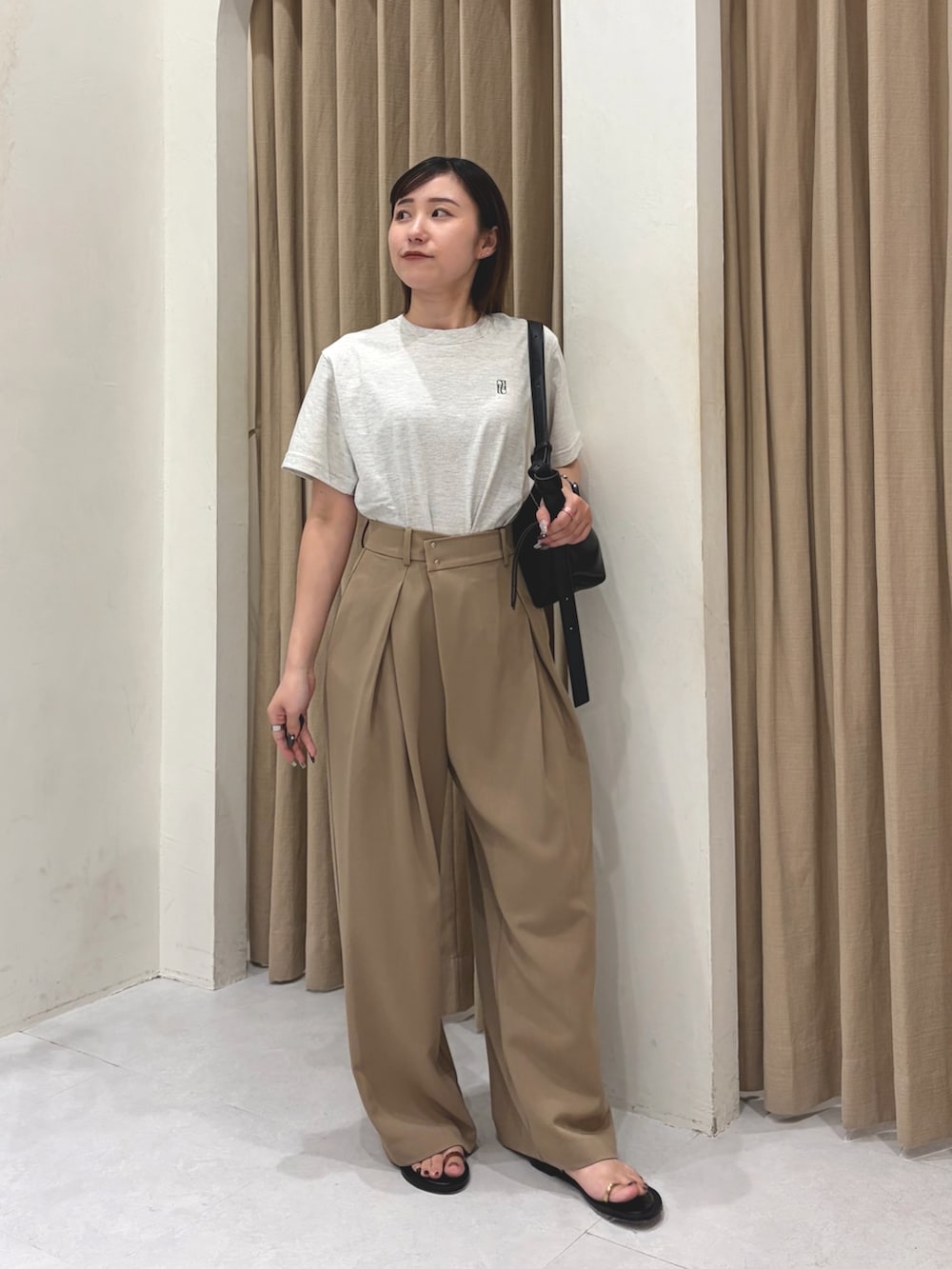 ブラック系のパンプス、グレー系のTシャツ/カットソー、ブラック系のバッグを着用したレディースの夏コーディネートの2枚目の写真