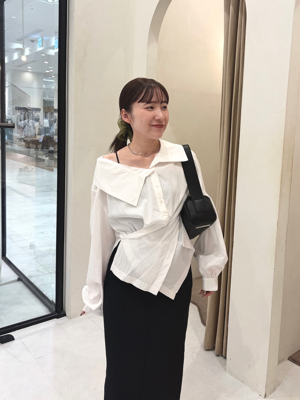 ホワイト系のシャツ/ブラウス、ブラック系のスカート、ブラック系のパンプスを着用したレディースの秋コーディネートの5枚目の写真
