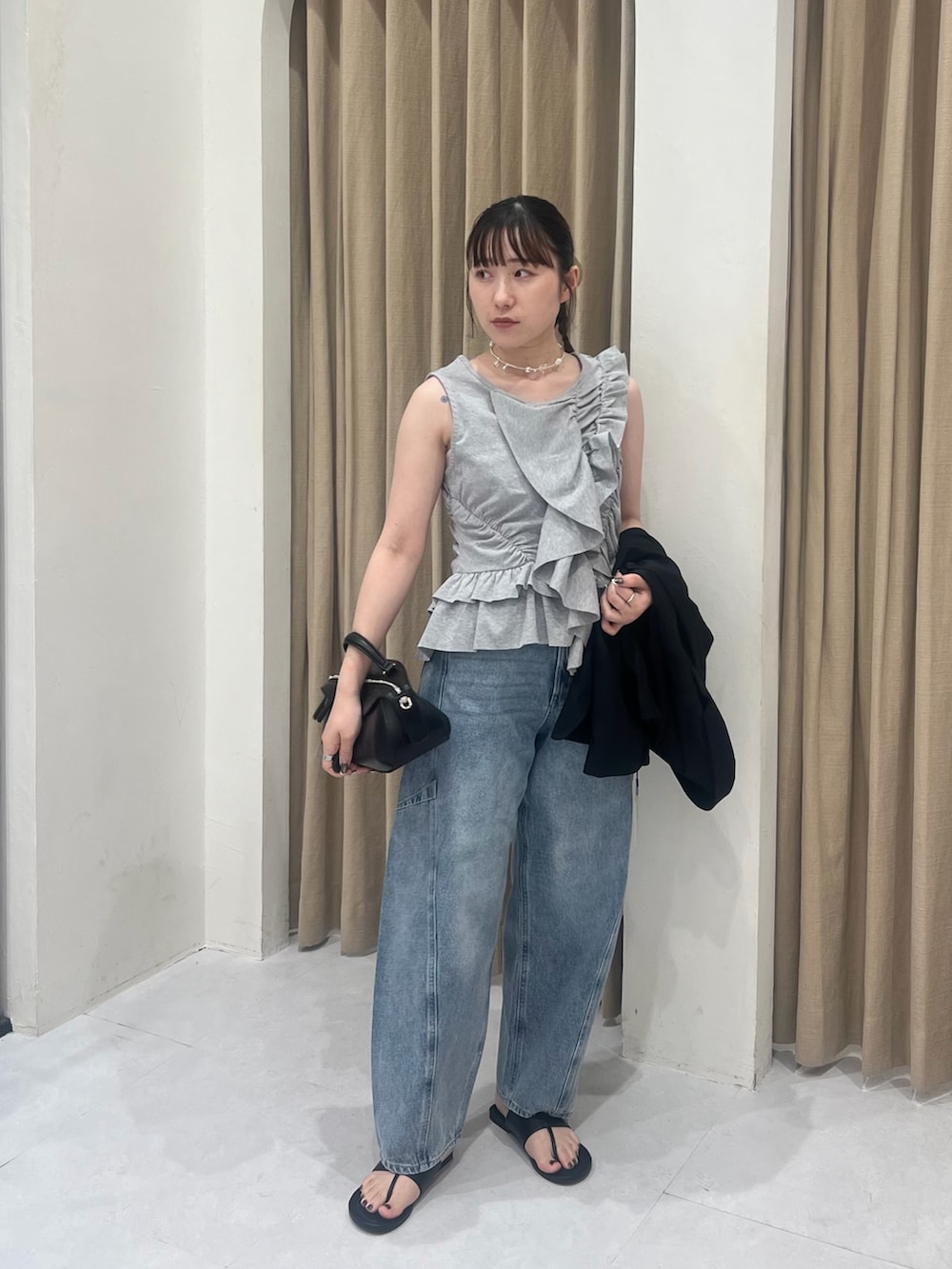 グレー系のTシャツ/カットソー、ブラック系のテーラードジャケット、ブルー系のデニムパンツを着用したレディースの春コーディネートの3枚目の写真