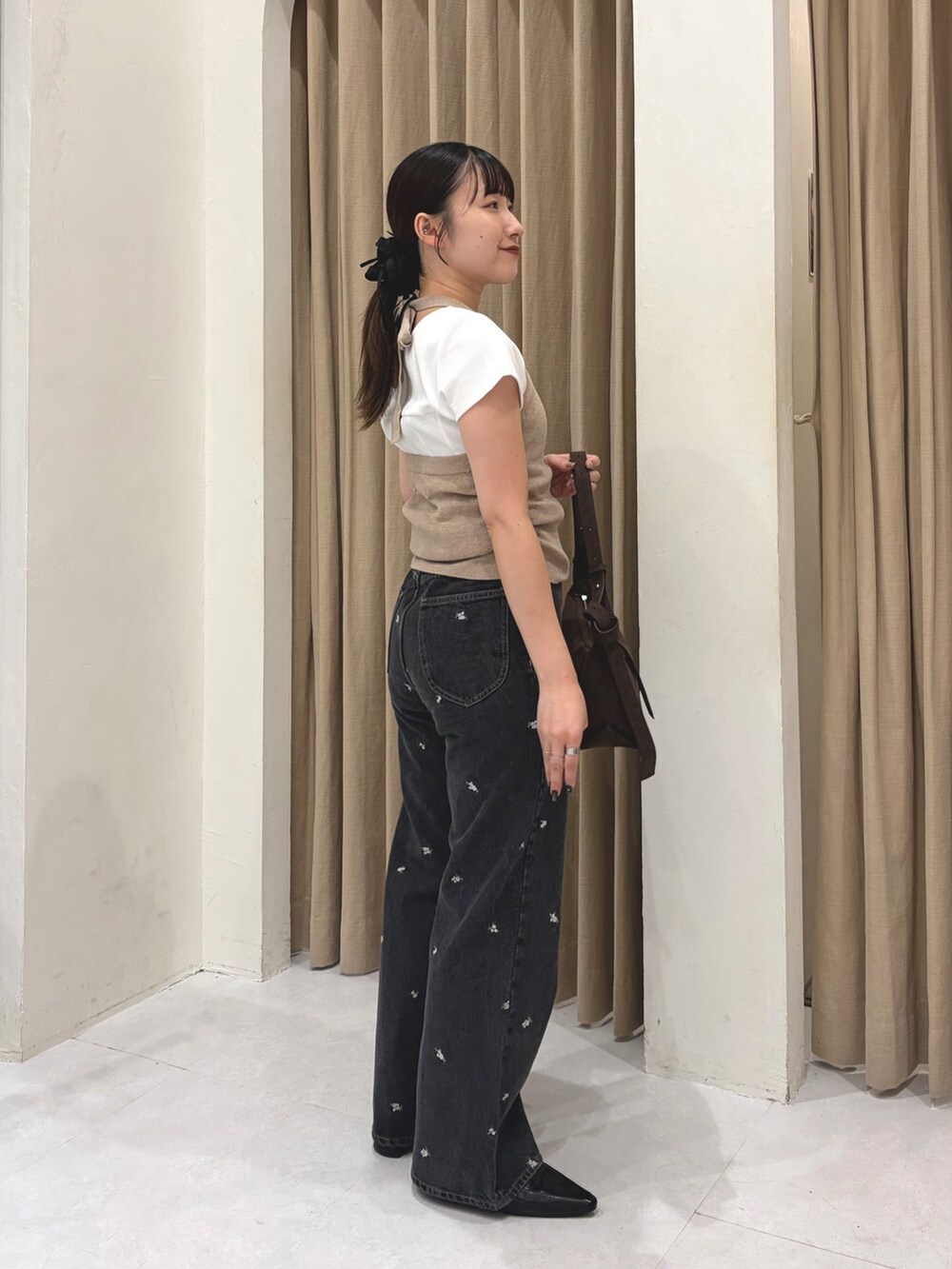 ブラック系のデニムパンツ、ブラウン系のトートバッグ、ブラック系のローファーを着用したレディースの夏コーディネートの2枚目の写真