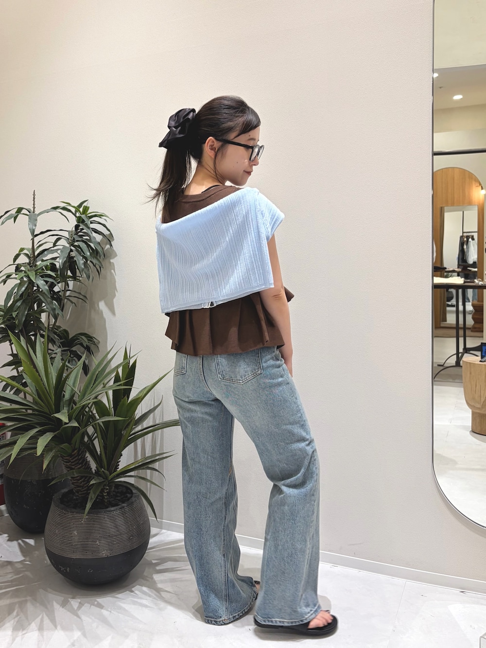 ブラウン系のニット/セーター、ブルー系のデニムパンツ、ブラック系のパンプスを着用したレディースの夏コーディネートの3枚目の写真