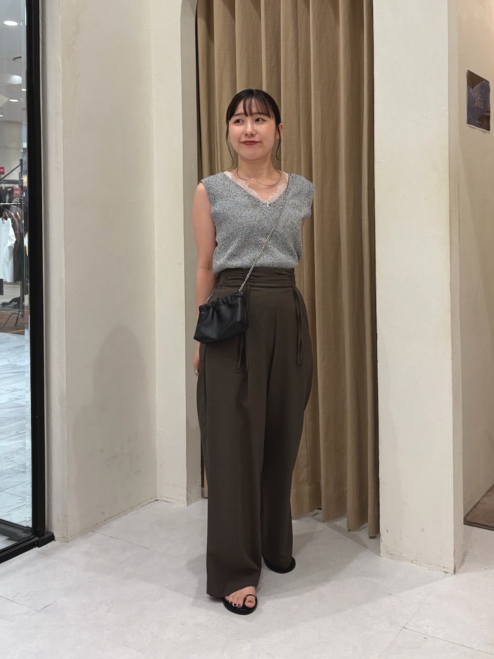 グレー系のニット/セーター、ブラウン系のその他パンツ、ブラック系のパンプスを着用したレディースの夏コーディネートの2枚目の写真
