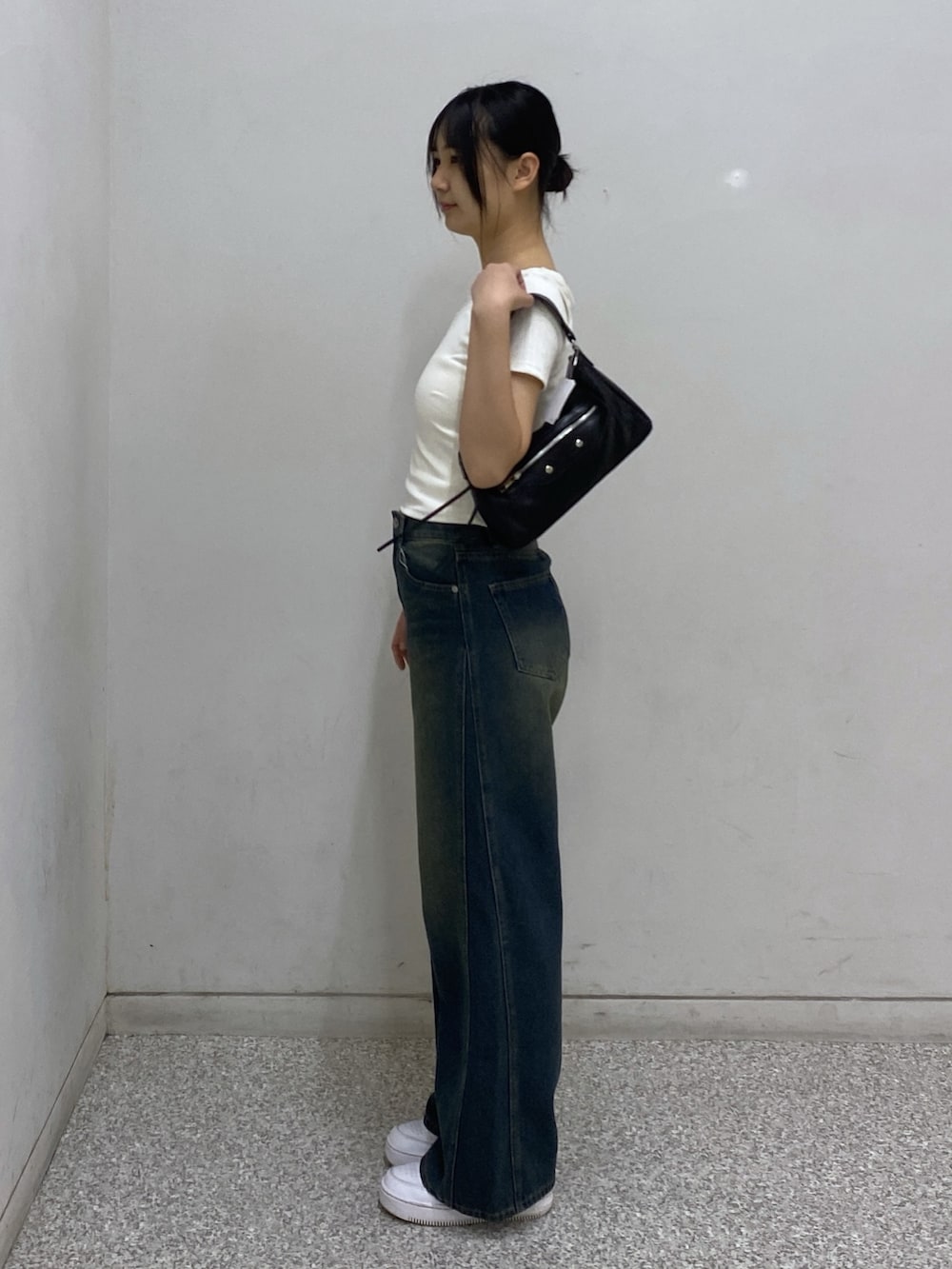 ブルー系のデニムパンツ、ホワイト系のTシャツ/カットソー、ブラック系のショルダーバッグを着用したレディースの夏コーディネートの2枚目の写真