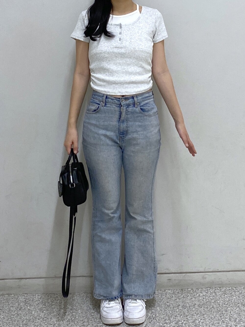 ブルー系のデニムパンツ、ブラック系のボストンバッグ、グレー系のTシャツ/カットソーを着用したレディースの夏コーディネートの2枚目の写真