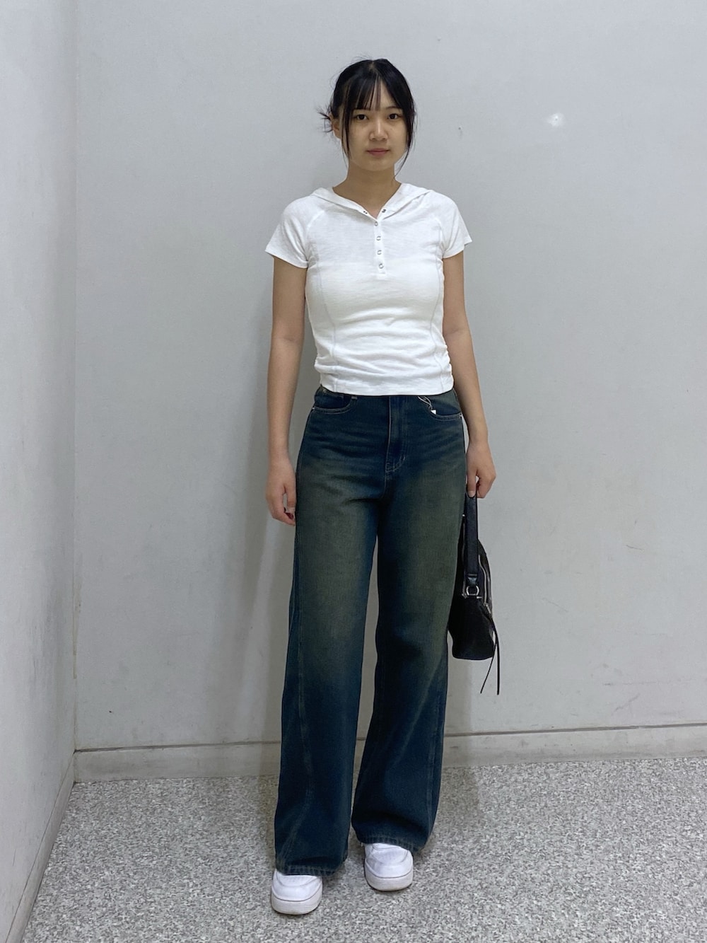 ブルー系のデニムパンツ、ブラック系のショルダーバッグ、ホワイト系のTシャツ/カットソーを着用したレディースの夏コーディネートの2枚目の写真