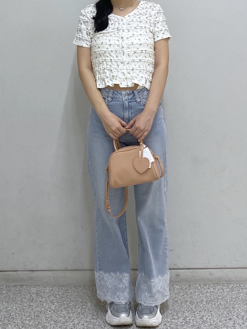 ピンク系のボストンバッグ、ホワイト系のTシャツ/カットソー、ブルー系のデニムパンツを着用したレディースの夏コーディネートの2枚目の写真