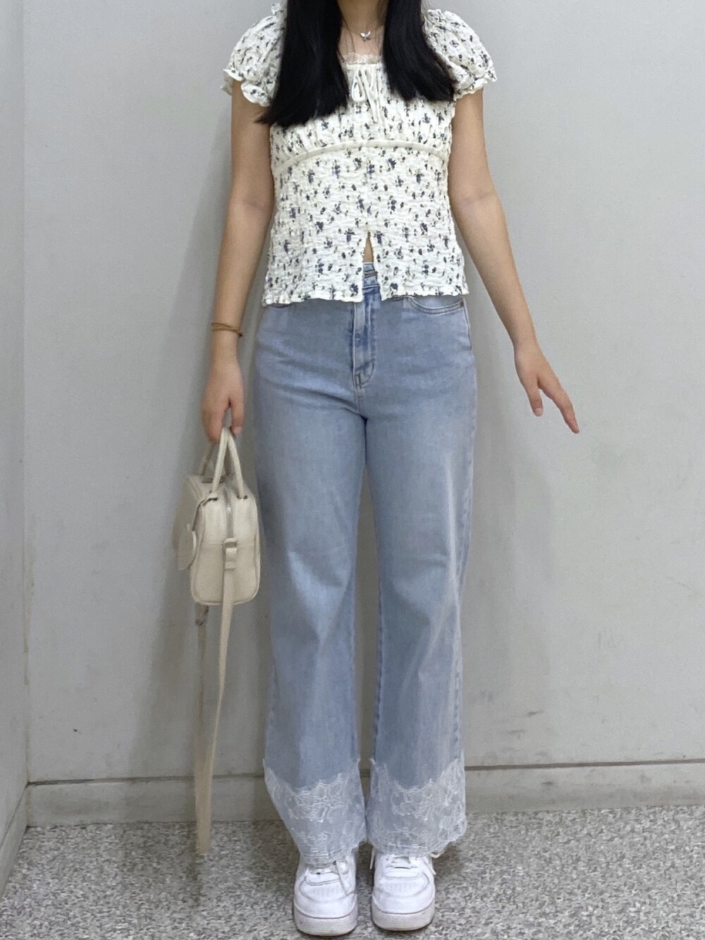 ホワイト系のボストンバッグ、ブルー系のデニムパンツ、ホワイト系のTシャツ/カットソーを着用したレディースの夏コーディネートの2枚目の写真