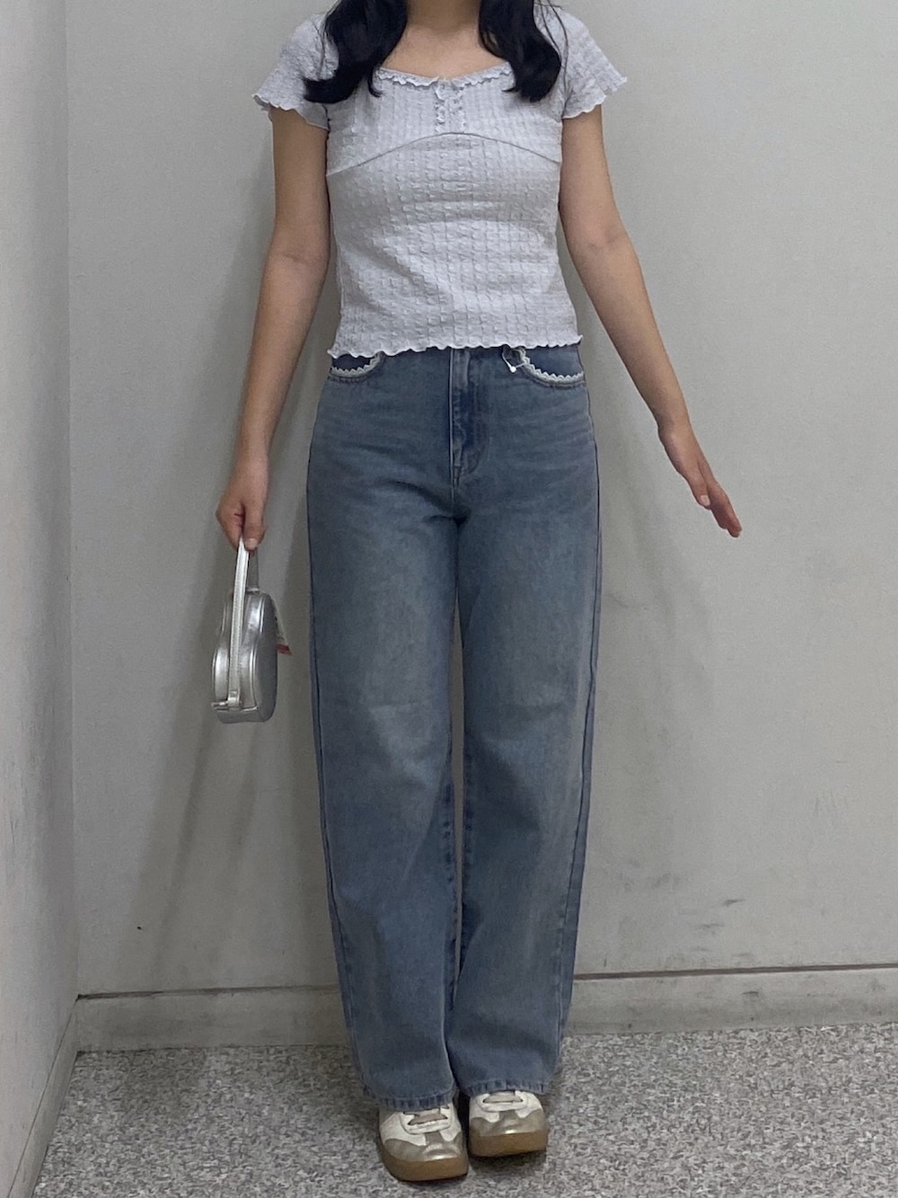 ブルー系のデニムパンツ、ブラウン系のTシャツ/カットソー、シルバー系のショルダーバッグを着用したレディースの春コーディネートの2枚目の写真
