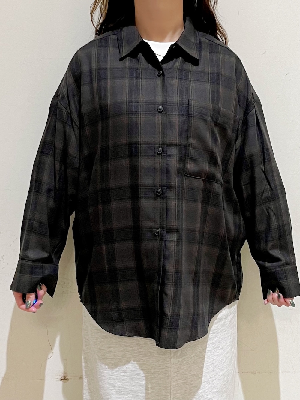 ブラウン系のシャツ/ブラウス、ホワイト系のTシャツ/カットソー、ブラック系のベストを着用したレディースの秋コーディネートの7枚目の写真