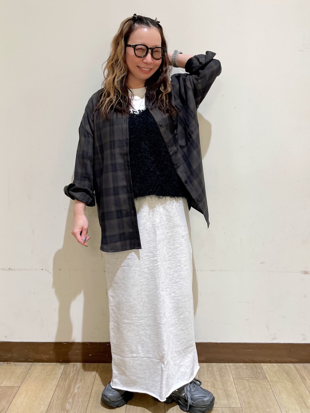 ブラウン系のシャツ/ブラウス、ホワイト系のTシャツ/カットソー、ブラック系のベストを着用したレディースの秋コーディネートの6枚目の写真