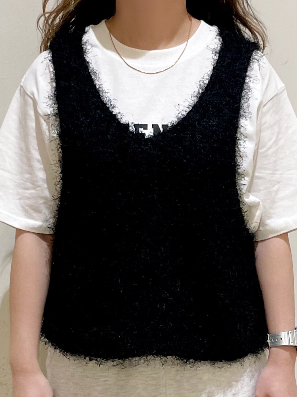 ブラウン系のシャツ/ブラウス、ホワイト系のTシャツ/カットソー、ブラック系のベストを着用したレディースの秋コーディネートの5枚目の写真
