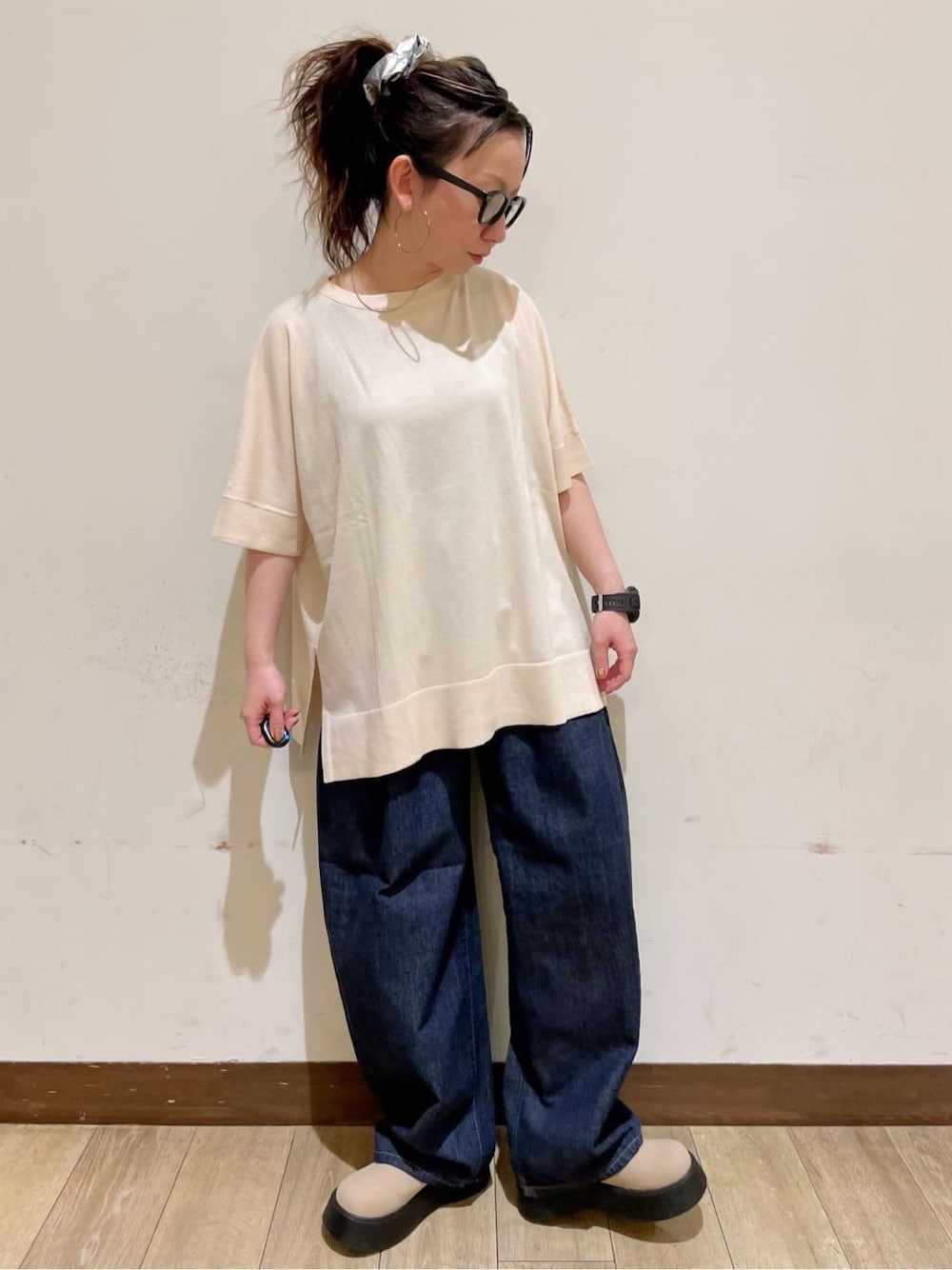 ホワイト系のベスト、ホワイト系のニット/セーター、ブルー系のデニムパンツを着用したレディースの春コーディネートの8枚目の写真