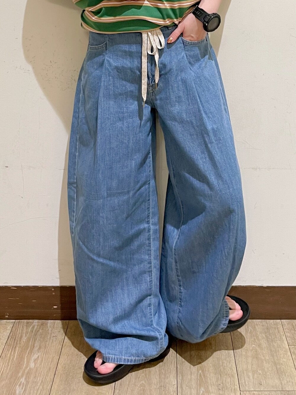 ブルー系のデニムパンツ、ベージュ系のショルダーバッグ、ブラック系のサンダルを着用したレディースの夏コーディネートの8枚目の写真