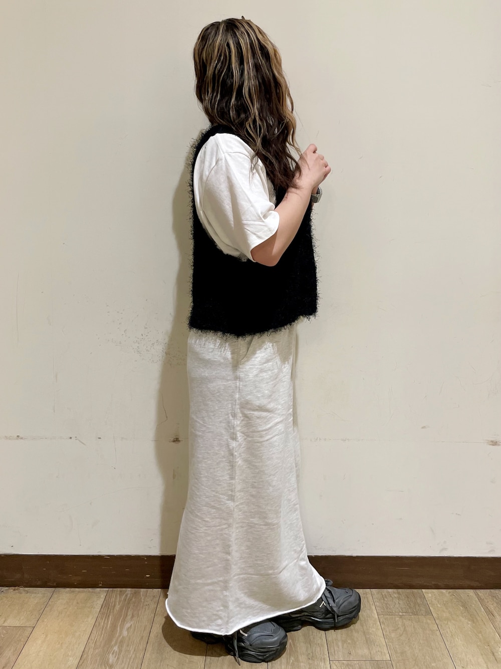 ブラウン系のシャツ/ブラウス、ホワイト系のTシャツ/カットソー、ブラック系のベストを着用したレディースの秋コーディネートの4枚目の写真