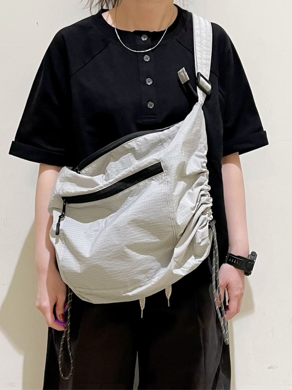 グレー系のショルダーバッグ、グレー系のその他パンツ、ブラック系のその他トップスを着用したレディースの春コーディネートの3枚目の写真