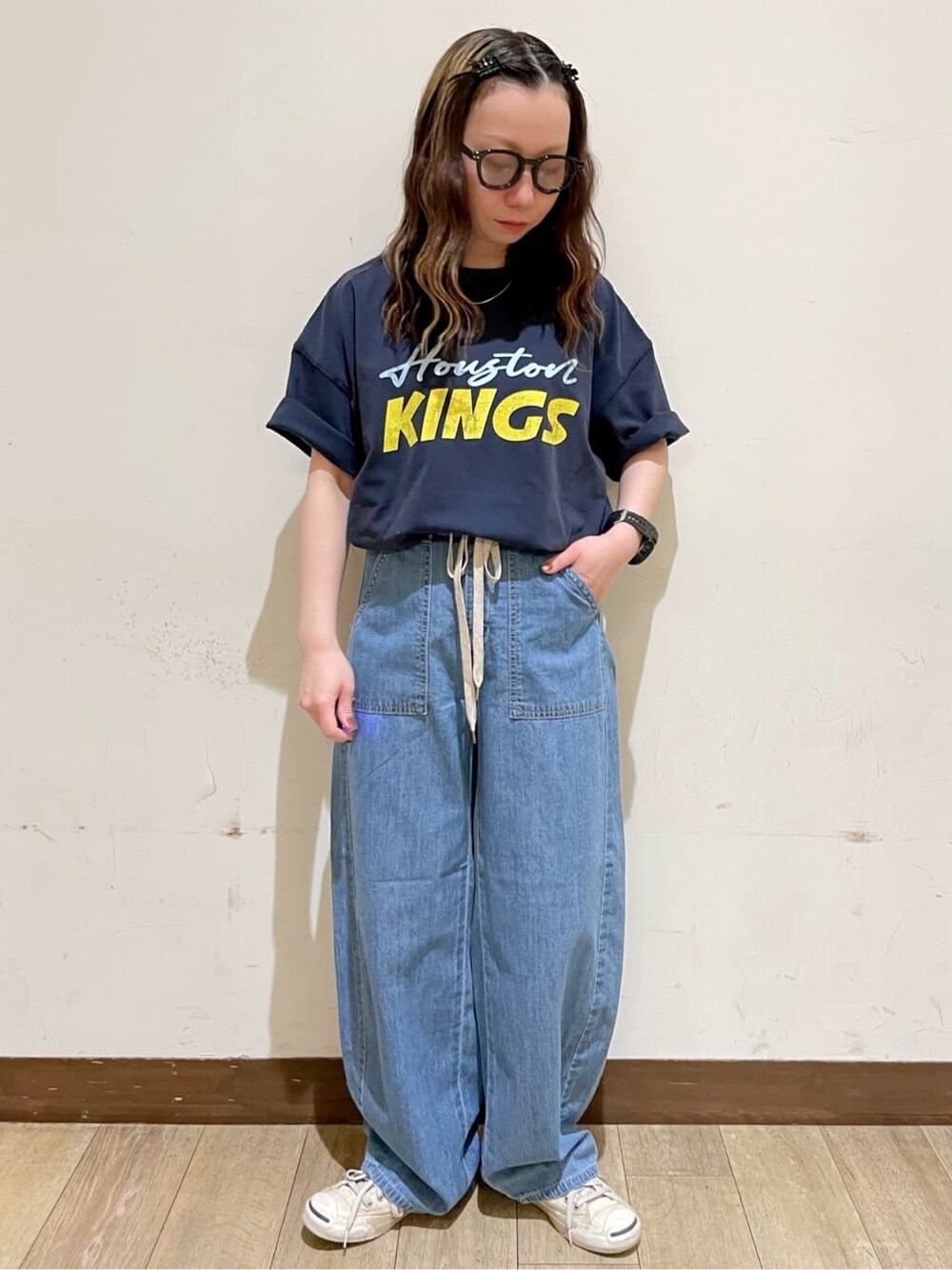 ブラウン系のショルダーバッグ、ブルー系のTシャツ/カットソー、ホワイト系のベストを着用したレディースの春コーディネートの6枚目の写真