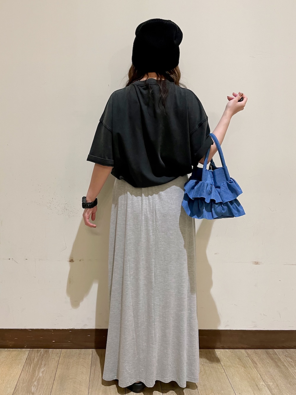 グレー系のTシャツ/カットソー、グレー系のスカート、ブラック系のサンダルを着用したレディースの夏コーディネートの2枚目の写真